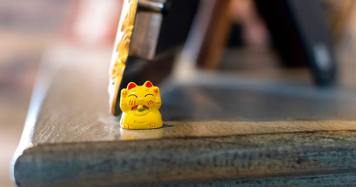 Maneki Neko colocado en una estantería de un hogar