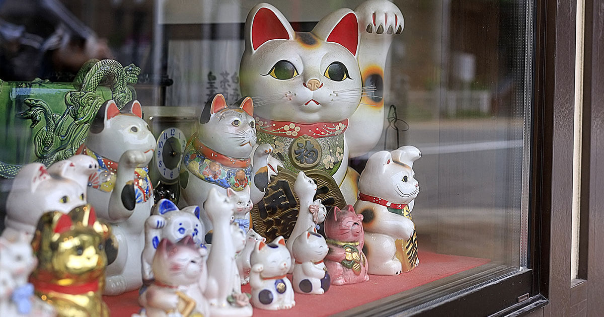 Escaparate con numerosos Maneki Neko con diferentes estilos y colores