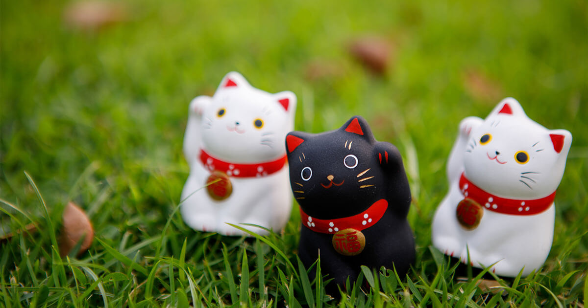 Figuras del Maneki Neko sobre el cesped